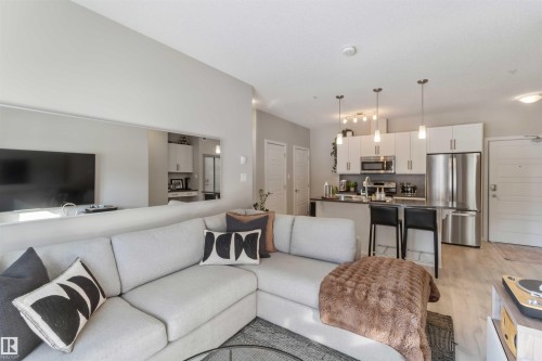 Living room featuring light wood-type flooring - 103 320 Ambleside Link Link Sw, Edmonton, AB - Indoor Photo Showing Living Room