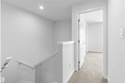 Hall with an upstairs landing and light carpet - 