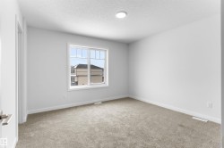Empty room with light colored carpet and a textured ceiling - 