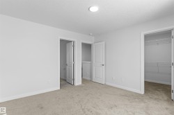Unfurnished bedroom with a walk in closet, light colored carpet, and a textured ceiling - 