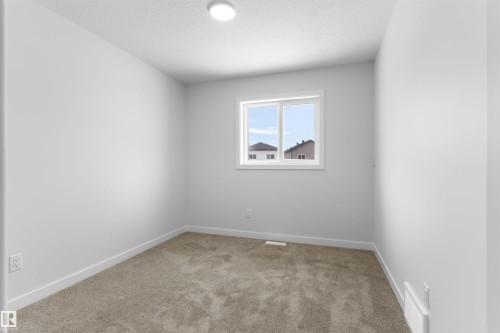Unfurnished room featuring light carpet and a textured ceiling - 320 Munn Way, Leduc, AB - Indoor Photo Showing Other Room
