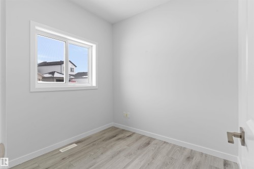 Unfurnished room with baseboards and light wood finished floors - 320 Munn Way, Leduc, AB - Indoor Photo Showing Other Room