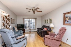 Living area featuring a ceiling fan, light wood finished floors, and a textured ceiling - 