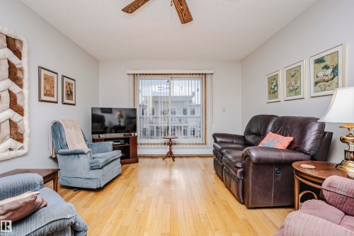 Living area featuring light wood-type flooring and ceiling fan - 408 10935 21 Avenue, Edmonton, AB - Indoor Photo Showing Living Room