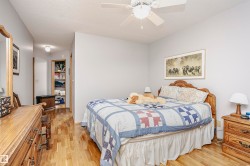 Bedroom featuring light wood-style flooring, a textured ceiling, and ceiling fan - 