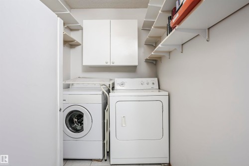Laundry room featuring cabinet space and washer and dryer - 408 10935 21 Avenue, Edmonton, AB - Indoor Photo Showing Laundry Room