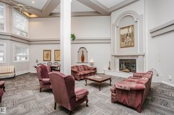 Living area featuring a high ceiling, a fireplace, a ceiling fan, recessed lighting, and carpet flooring - 