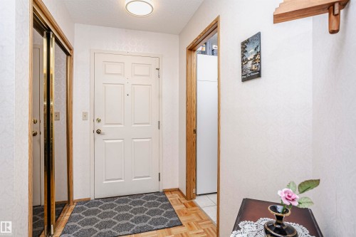 Foyer featuring a textured ceiling and parquet flooring - 408 10935 21 Avenue, Edmonton, AB - Indoor Photo Showing Other Room
