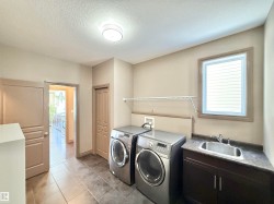 Laundry area featuring washer and clothes dryer, a textured ceiling, light tile patterned floors, and cabinet space - 