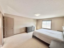Carpeted bedroom with a textured ceiling and baseboards - 