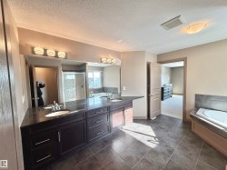 Bathroom featuring double vanity, a bath, a shower stall, and a textured ceiling - 