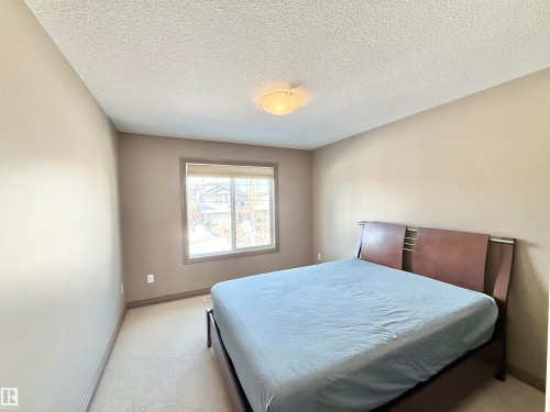 Bedroom with a textured ceiling and light colored carpet - 1019 174 Street, Edmonton, AB - Indoor Photo Showing Bedroom
