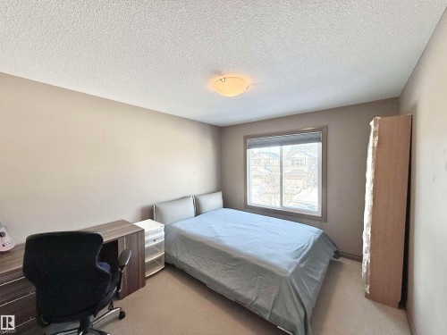 Bedroom featuring carpet floors, a textured ceiling, and a desk - 1019 174 Street, Edmonton, AB - Indoor Photo Showing Bedroom