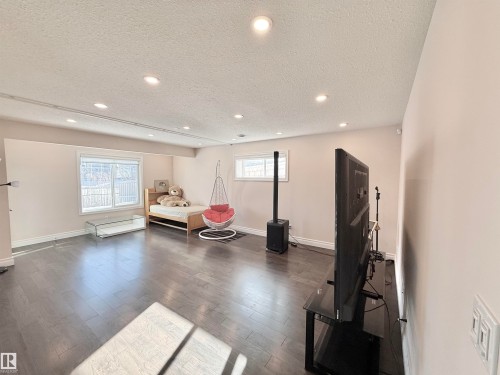 Exercise room with a textured ceiling, recessed lighting, and wood finished floors - 1019 174 Street, Edmonton, AB - Indoor