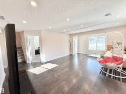 Living room featuring wood finished floors, recessed lighting, and a textured ceiling - 