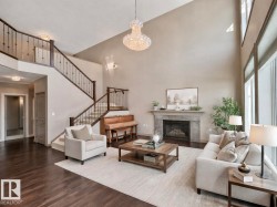 Living area with a fireplace, a high ceiling, dark wood finished floors, and a chandelier - 