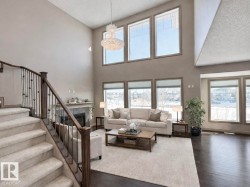 Living area featuring a high end fireplace, dark wood-style flooring, and a high ceiling - 