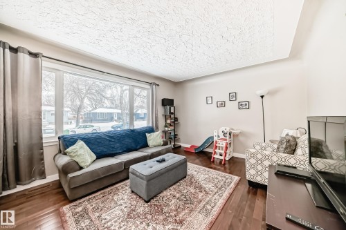 Living area with dark wood finished floors and baseboards - 12332 129 Street, Edmonton, AB - Indoor Photo Showing Living Room