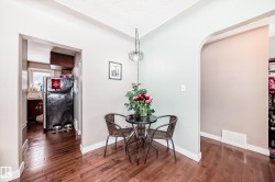 Dining area featuring dark wood-style floors, arched walkways, and vaulted ceiling - 