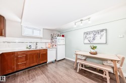 Kitchen featuring wood finish cabinetry, white appliances, light wood finished floors, and tasteful backsplash - 