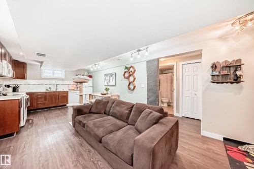 Living room featuring light wood-style floors and rail lighting - 12332 129 Street, Edmonton, AB - Indoor