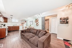 Living room featuring light wood-style floors and rail lighting - 