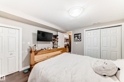 Bedroom featuring dark wood-style flooring and multiple closets - 