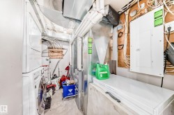 Unfinished basement with electric panel, gas water heater, and stacked washer / drying machine - 