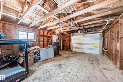 Garage with wooden walls, a garage door opener, and fridge - 12332 129 Street, Edmonton, AB - Indoor Photo Showing Garage