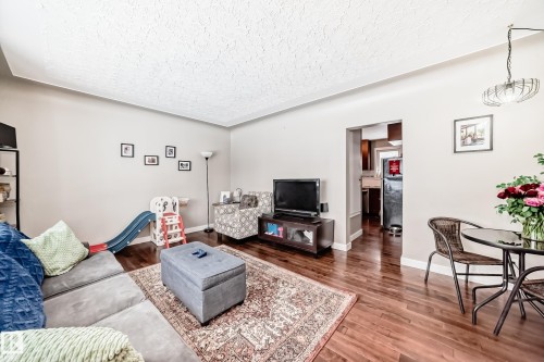 Living area featuring wood finished floors and a textured ceiling - 12332 129 Street, Edmonton, AB - Indoor Photo Showing Living Room