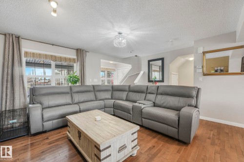 Living area featuring dark wood-type flooring and a textured ceiling - 281 Southwick Way, Leduc, AB - Indoor Photo Showing Living Room