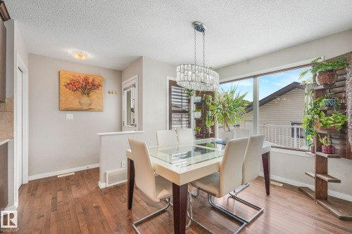 Dining space with dark wood-style floors, a textured ceiling, and hanging lights - 281 Southwick Way, Leduc, AB - Indoor Photo Showing Dining Room