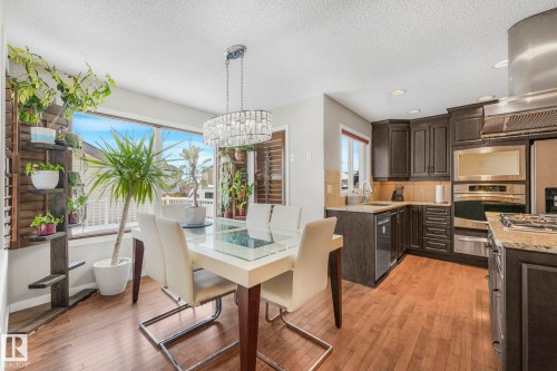 Dining area featuring light wood-style floors, a textured ceiling, and a chandelier - 281 Southwick Way, Leduc, AB - Indoor Photo Showing Dining Room