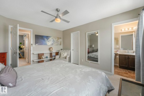 Bedroom featuring ensuite bath, a textured ceiling, ceiling fan, a closet, and light colored carpet - 281 Southwick Way, Leduc, AB - Indoor Photo Showing Bedroom