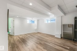 Basement with a drop ceiling, light wood-type flooring, and healthy amount of natural light - 