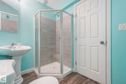 Full bathroom featuring dark wood-style flooring and a shower stall - 