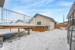 View of snowy exterior featuring a hot tub and a deck - 