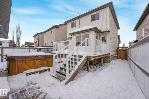Snow covered rear of property with a wooden deck, a hot tub, and a fenced backyard - 281 Southwick Way, Leduc, AB - Outdoor With Deck Patio Veranda With Exterior