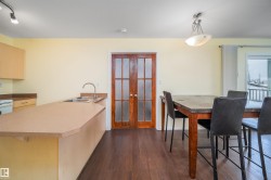 Dining area with dark wood finished floors and french doors - 