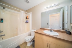 Full bathroom with vanity, shower / bath combination with curtain, and light tile patterned floors - 