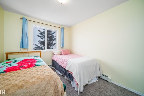 Bedroom featuring carpet and a baseboard radiator - 211 4310 33 Street, Stony Plain, AB - Indoor Photo Showing Bedroom