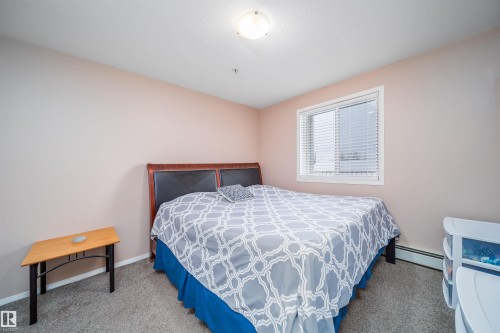 Carpeted bedroom with a baseboard radiator and baseboards - 211 4310 33 Street, Stony Plain, AB - Indoor Photo Showing Bedroom