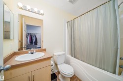 Bathroom with vanity, shower / bath combination with curtain, and a walk in closet - 