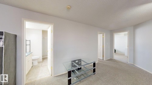 Hall with light carpet and a textured ceiling - 17010 84 Street, Edmonton, AB - Indoor