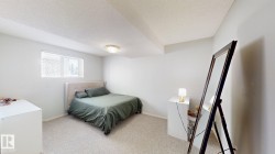 Bedroom with a textured ceiling and light colored carpet - 