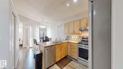 Kitchen with stainless steel appliances, light countertops, backsplash, light wood finish cabinets, and a peninsula - 