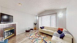 Living room featuring light wood-style flooring and a tile fireplace - 