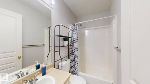Bathroom with a textured ceiling, shower / tub combo, and vanity - 17010 84 Street, Edmonton, AB - Indoor Photo Showing Bathroom