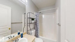 Bathroom with a textured ceiling, shower / tub combo, and vanity - 