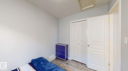 Bedroom with light wood-style flooring, a textured ceiling, and a closet - 